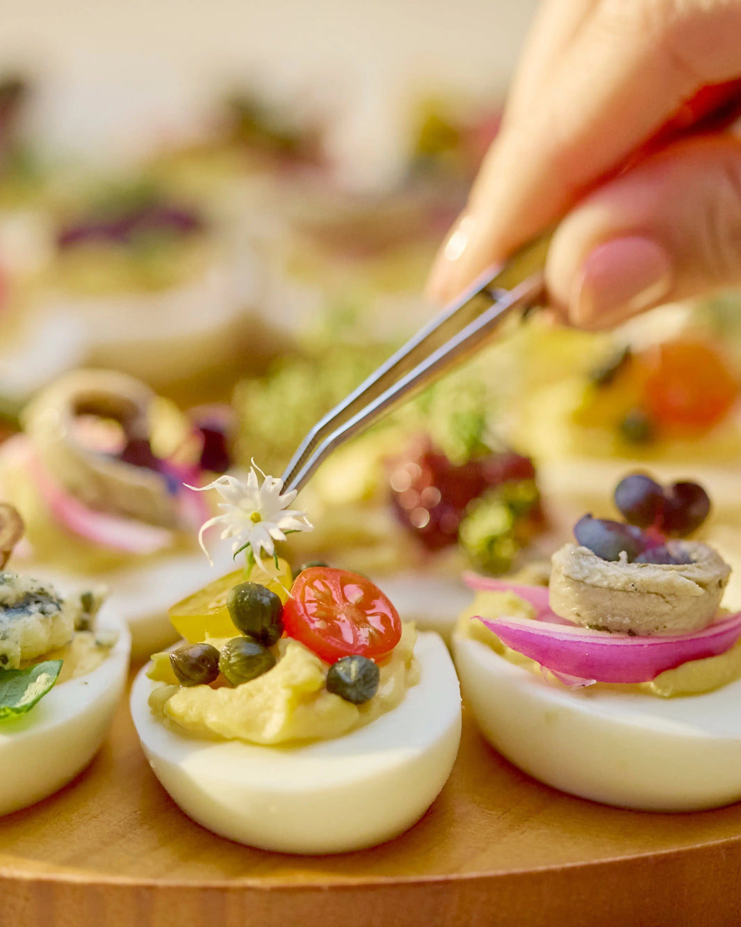 Devilled eggs tasting flight with creamy whipped yolk filling and gourmet toppings including smoked salmon, olives, tapenade and truffle salt.